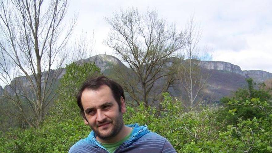 Mikel Kormenzana, en su plantación de arbustos de agrazón y con unos tarros de sus mermeladas. Foto: S. Martín