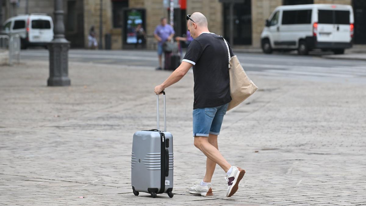 Un turista caminando con su maleta.