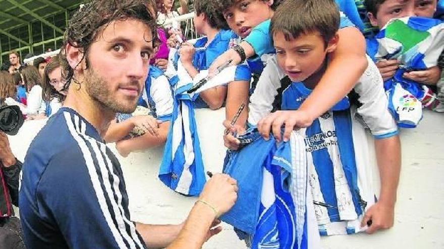 Granero firma autógrafos a los niños que se acercaron ayer por la tarde a Zubieta, en su primer entrenamiento de esta temporada como txuri-urdin.