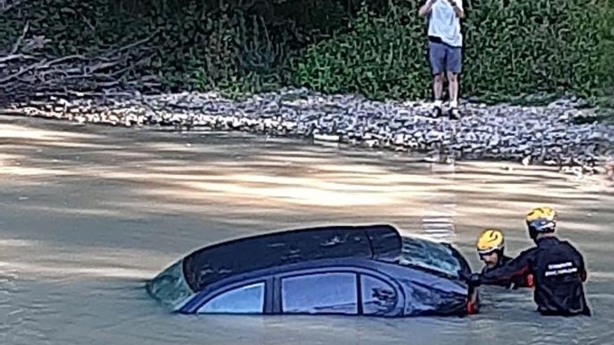 Los bomberos extraen un coche caído al río Ultzama a su paso por Arre