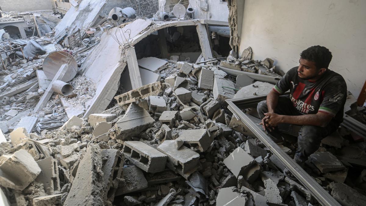 Un hombre observa los destrozos desde el interior de una vivienda tras un bombardeo israelí sobre la ciudad de Gaza.