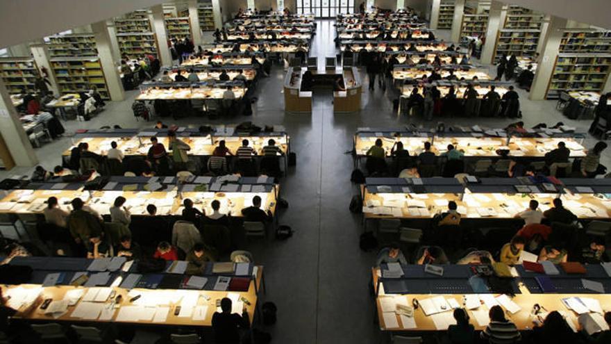 Vista general del interior de la biblioteca de la UPNA, llena de estudiantes.
