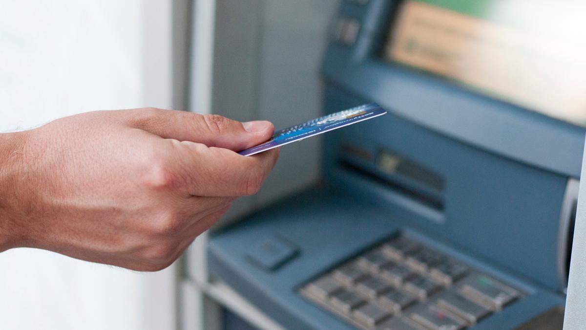 Una persona extrae dinero en una entidad bancaria