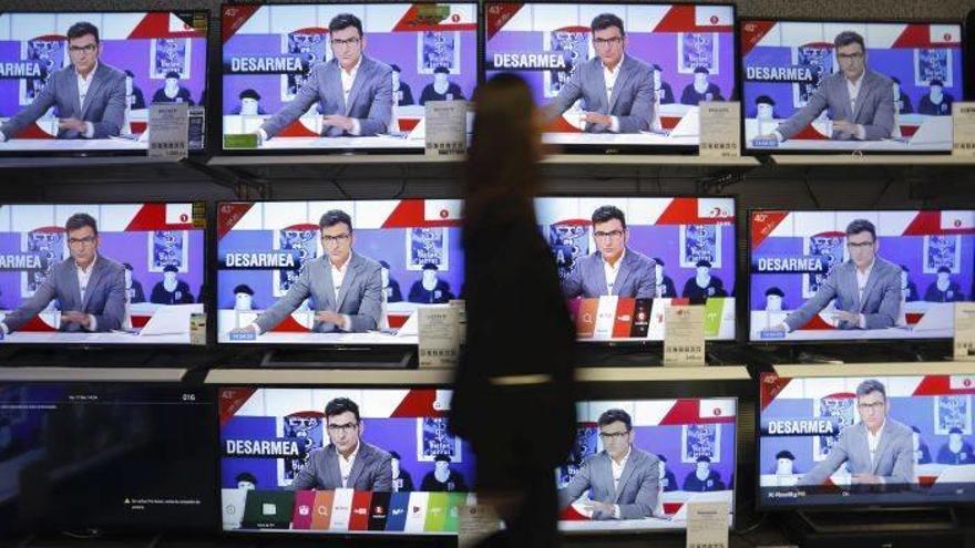 En la imagen una mujer observa la informacion en los informativos de las diferentes cadenas de television