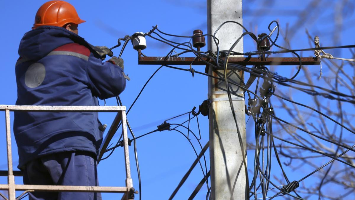 Un operario trata de recomponer una red energética dañada tras un ataque ruso.