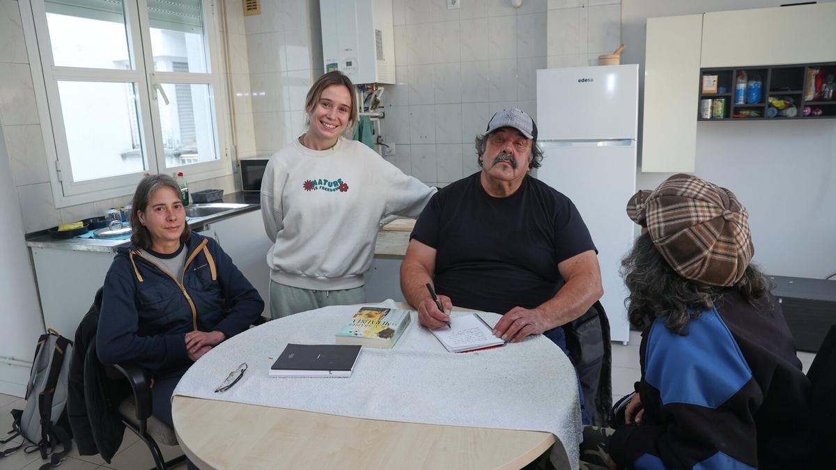 De izquierda a derecha, Joana, Inés Álvarez, educadora social, Antonio y Nines, de espaldas, en la vivenda municipal que comparten gracias al programa del área de Acción Social y la fundación Adsis con personas que vivían en la calle.