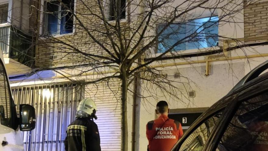 Un bombero y un policía observan los efectos del incendio en el exterior del edificio