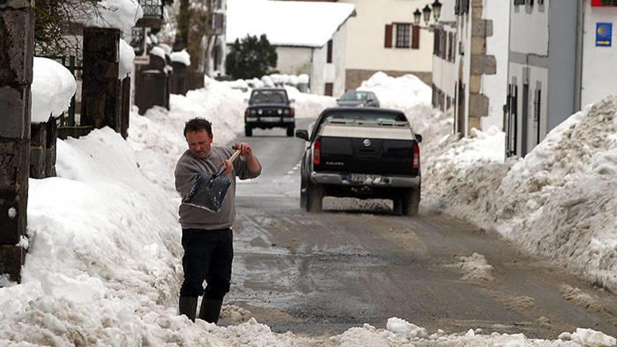 Un hombre retira nieve con una pala en Burguete.