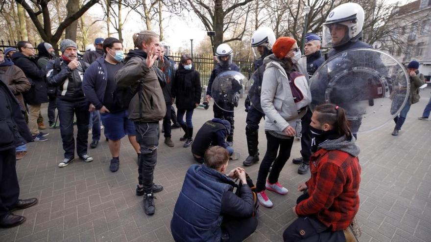 Agentes policiales belgas controlan a varios participantes en la protesta de Bruselas.