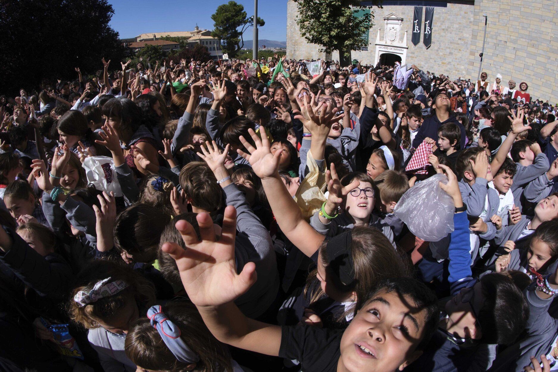 Los txikis esperan ansiosos la caída de los dulces en la plaza de San Fermín de Aldapa.