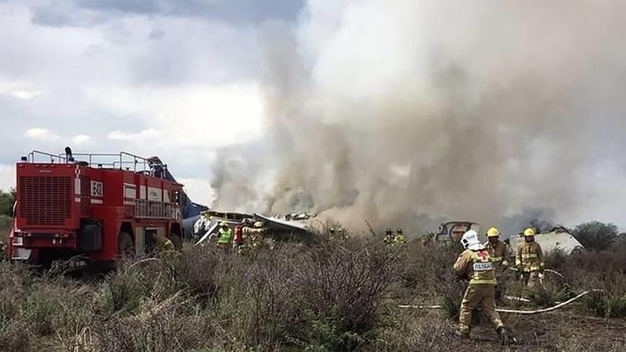Los bomberos ayudan a apagar el incendio del avión