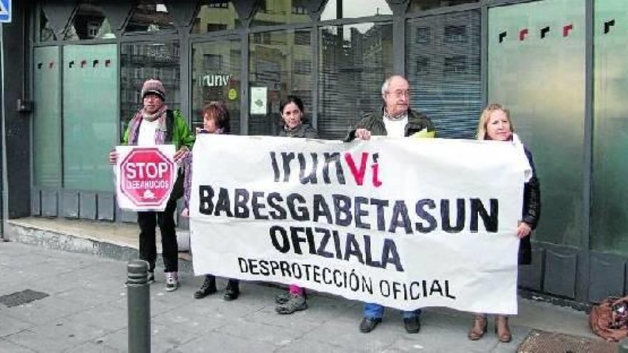 Integrantes de Stop Desahucios Bidasoa, con una pancarta de protesta ayer, ante la sede de Irunvi.