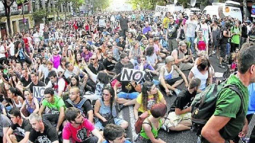 Numerosas personas se volvieron a concentrar ayer frente a la sede madrileña del PP en protesta por las medidas decretadas.