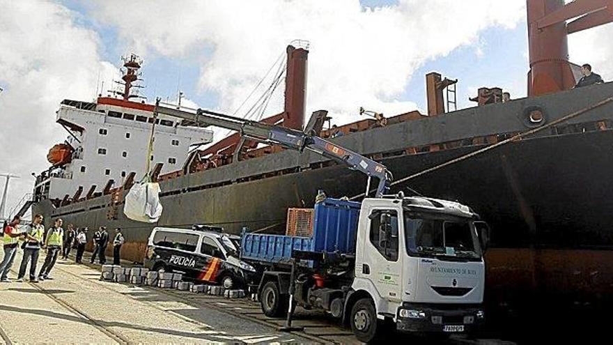 Una grúa descarga en el puerto de Cádiz la cocaína hallada a bordo del mercante interceptado.