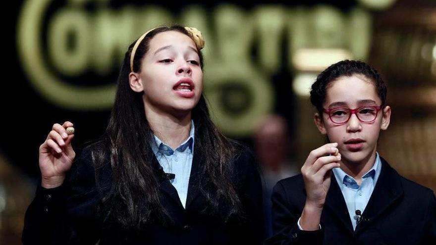 Los niños de San Ildefonso Noura Akrouh (d) y Elizabeth del Carmen Roque (i) muestran el número 04211 que ha sido agraciado con el tercer premio.