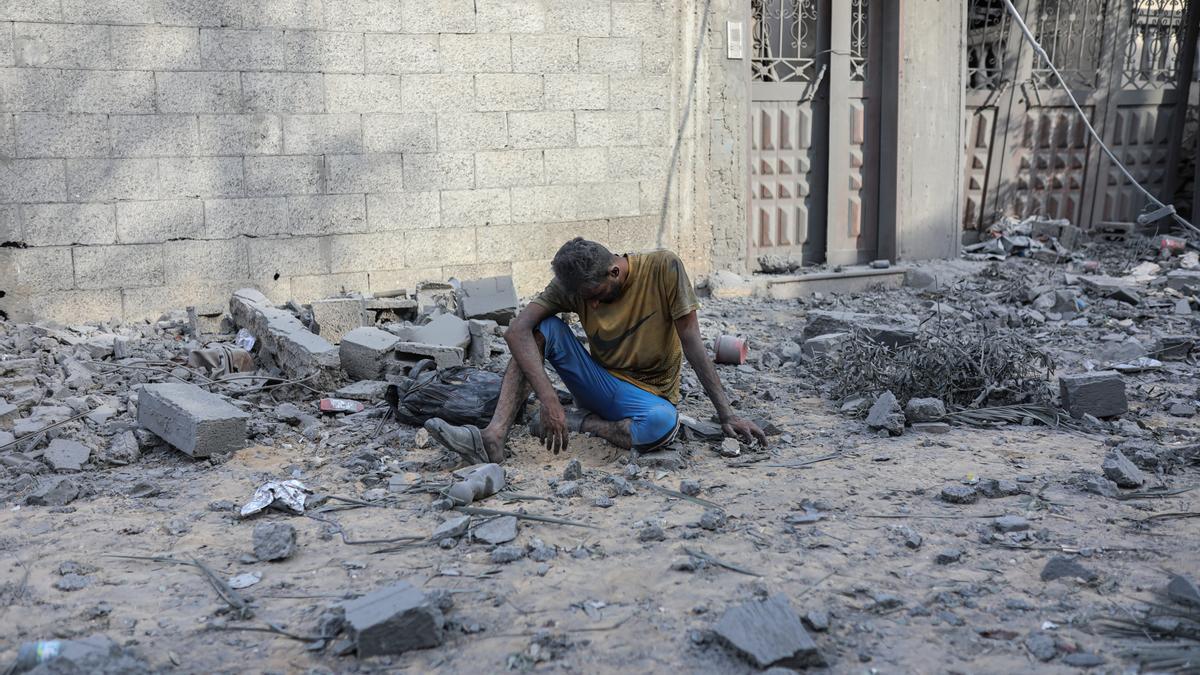 Un hombre en Palestina, se sienta en medio de un edificio destruido tras un ataque de Israel.