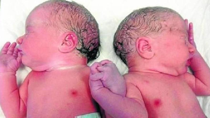 Fotografía facilitada por la familia de Danel (d) y María (i), que nada más nacer se buscaron en la cuna y unieron sus manos.