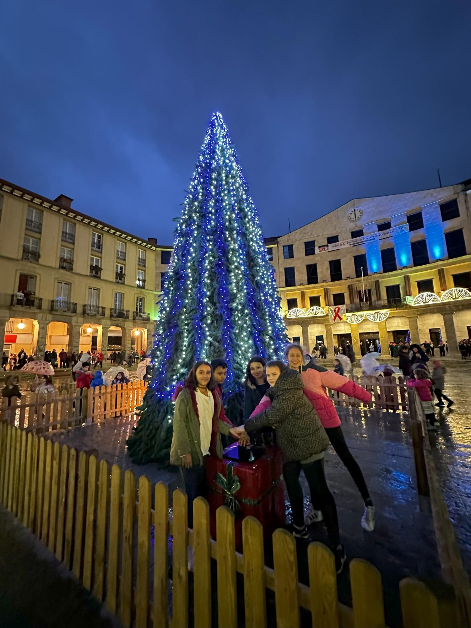 Un grupo de escolares presionando el botón de encendido navideño en la Herriko Plaza de Laudio