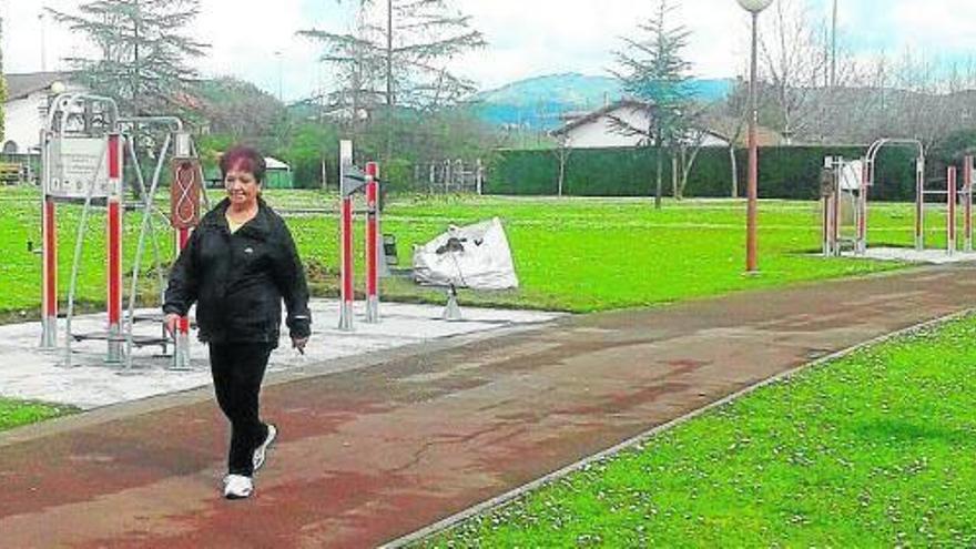 Una mujer pasea junto a los aparatos instalados hace poco en el parque Larrabarrena.