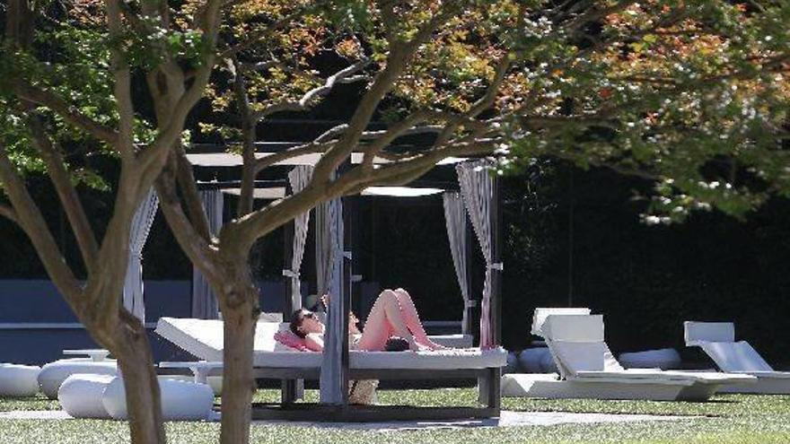 Una turista descansa en los jardines de un hotel donostiarra.