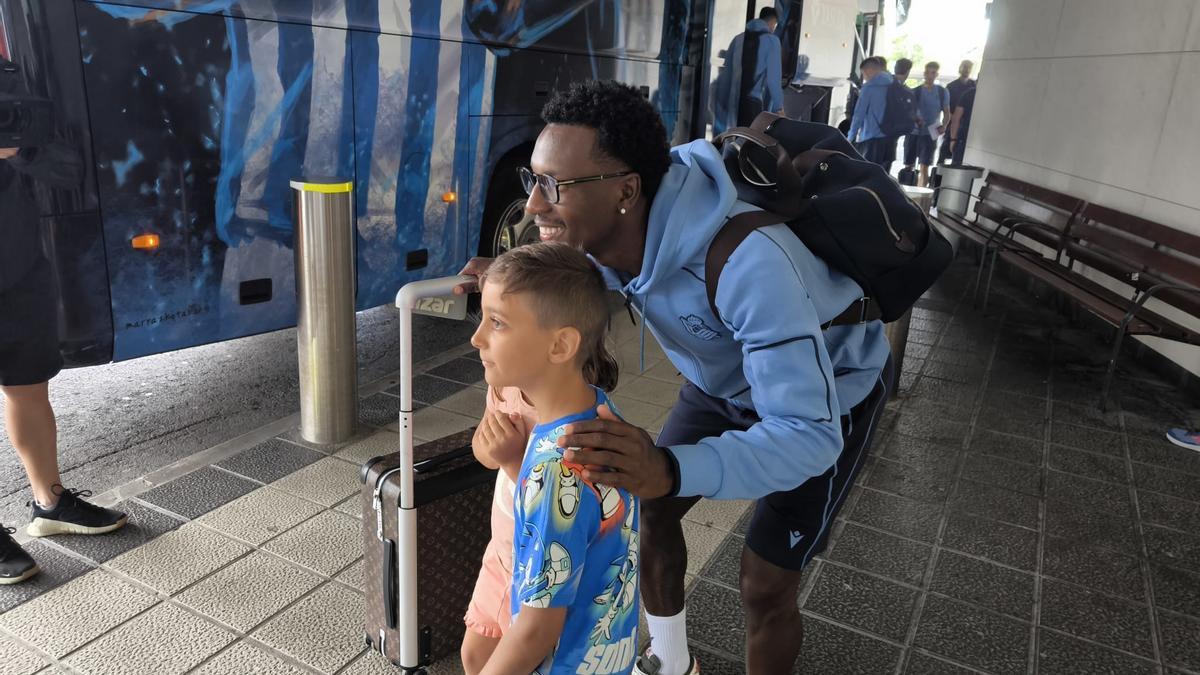 El jugador de la Real Sociedad Sheraldo Becker posa con dos jóvenes en el aeropuerto de Hondarribia antes de partir a Japón