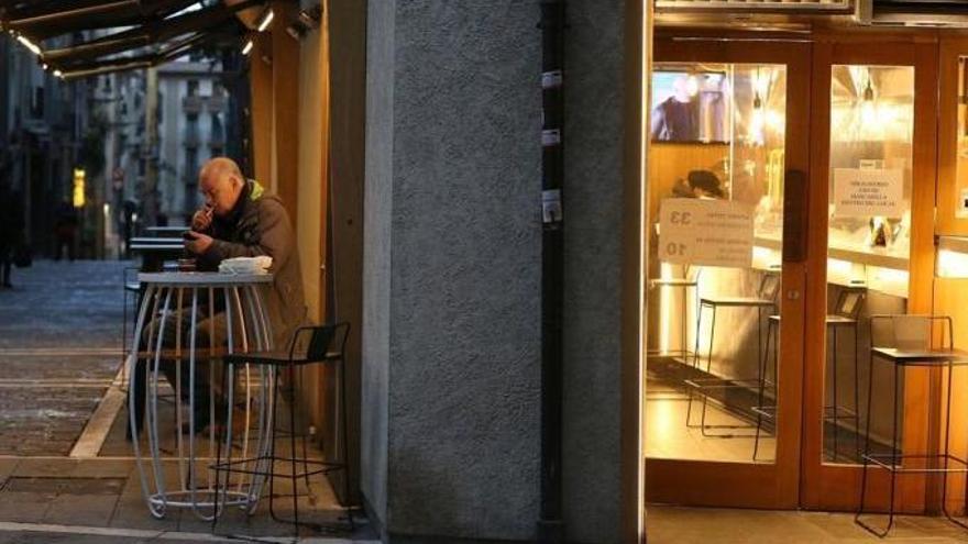 Un cliente fumando en una terraza de un bar de Iruñea.