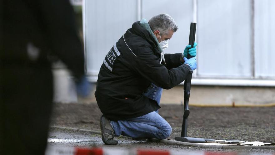 Un policía examina un arma en el campus universitario.