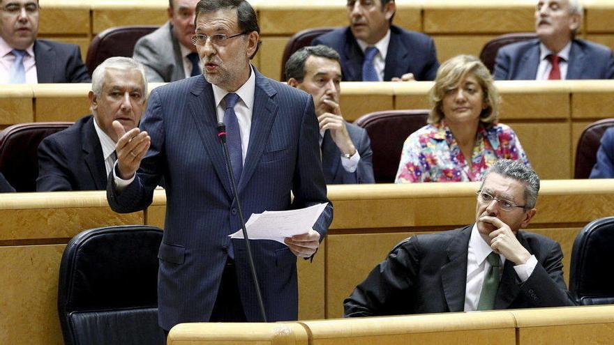 El presidente del Gobierno, Mariano Rajoy, junto al ministro de Justicia, Alberto Ruiz Gallardón (d), durante su intervención en la sesión de control al Gobierno, esta tarde en el pleno del Senado.