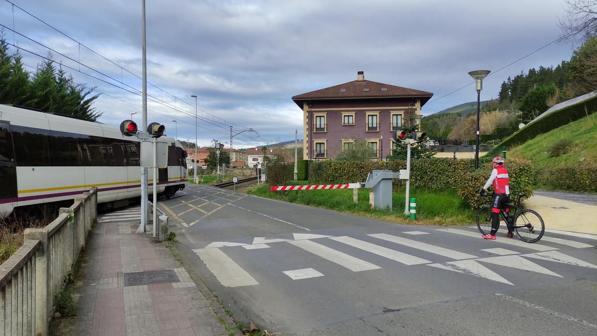 Un tren atraviesa un paso a nivel con barreras frente a la Casa Pinta.