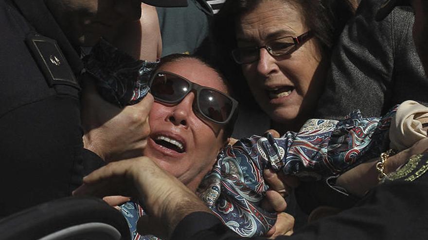 La tonadillera Isabel Pantoja, que ha sido condenada hoy a dos años de cárcel por blanqueo de capitales, es ayudada a entrar a su vehículo tras salir de la Audiencia Provincial de Málaga y sufrir zarandeos, abucheos y gritos de &quot;ladrona&quot;, y &amp;quo