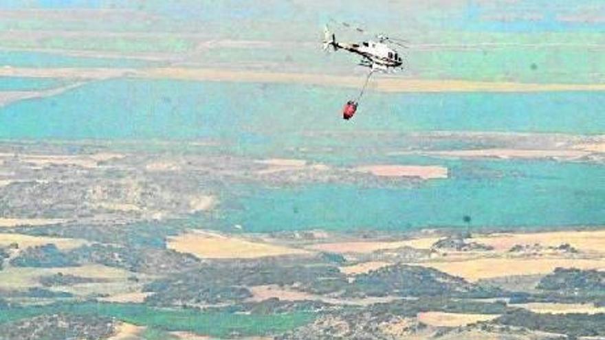 Helicópteros bombean agua en la zona afectada a primera hora de la mañana de ayer.