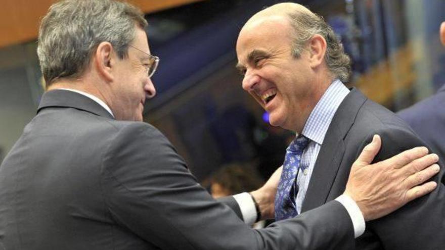 El ministro español Luis de Guindos saluda al presidente del BCE Mario Draghi