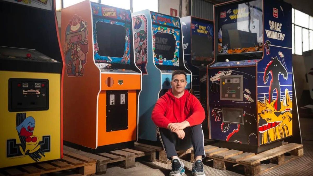 Tomás Lorente posa con varias de las máquinas de videojuegos que posee.