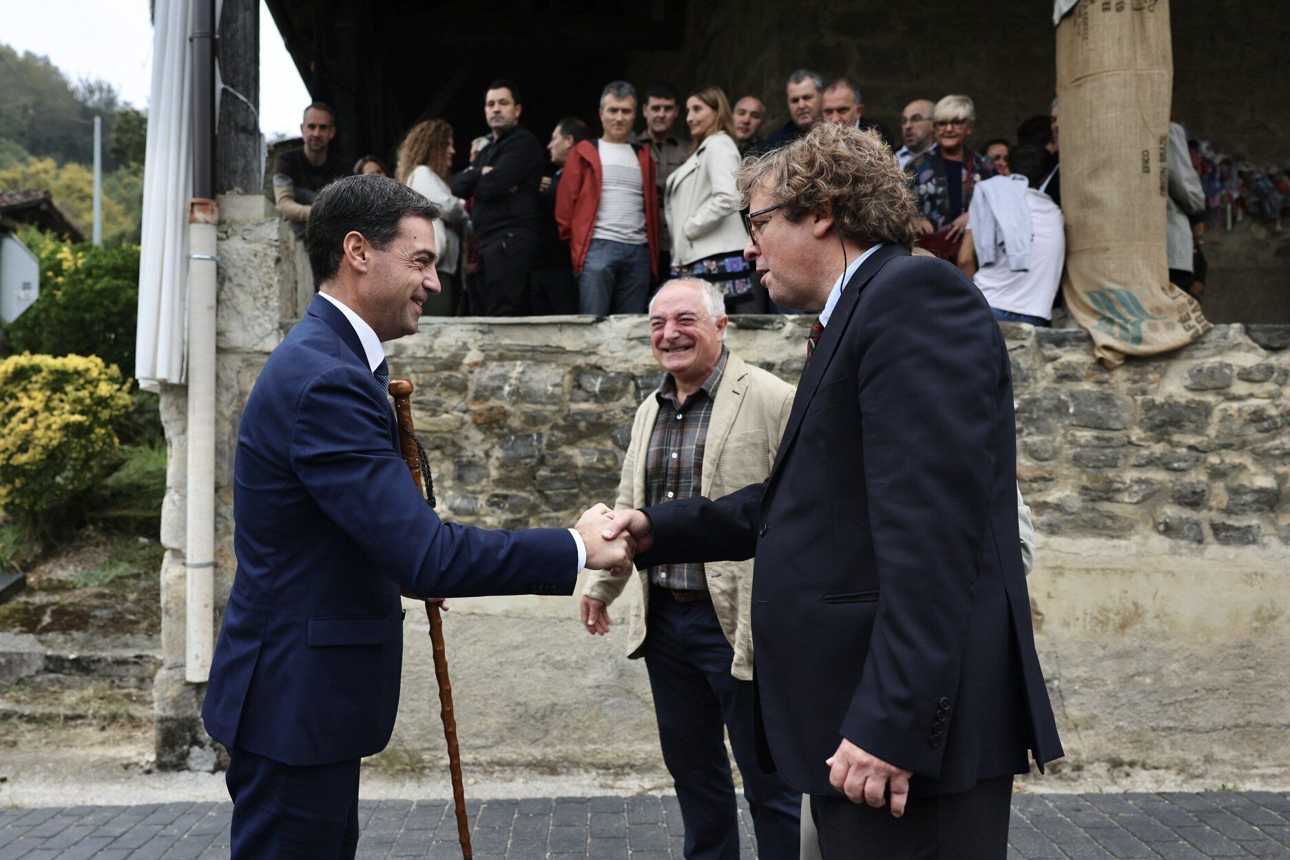 El lehendakari, Imanol Pradales, saluda a Xabier Ezeizabarrena, ante la mirada del alcalde de Altzo, Xabier Olano