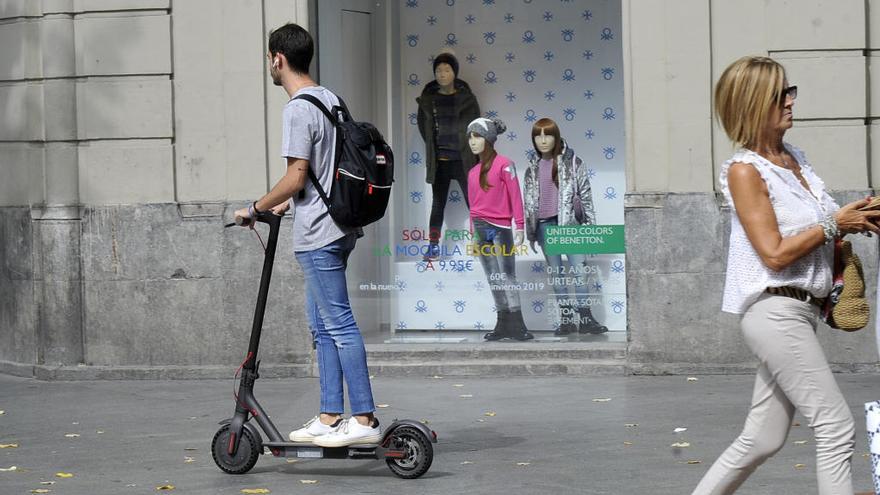 Un joven circula con un patinete eléctrico.