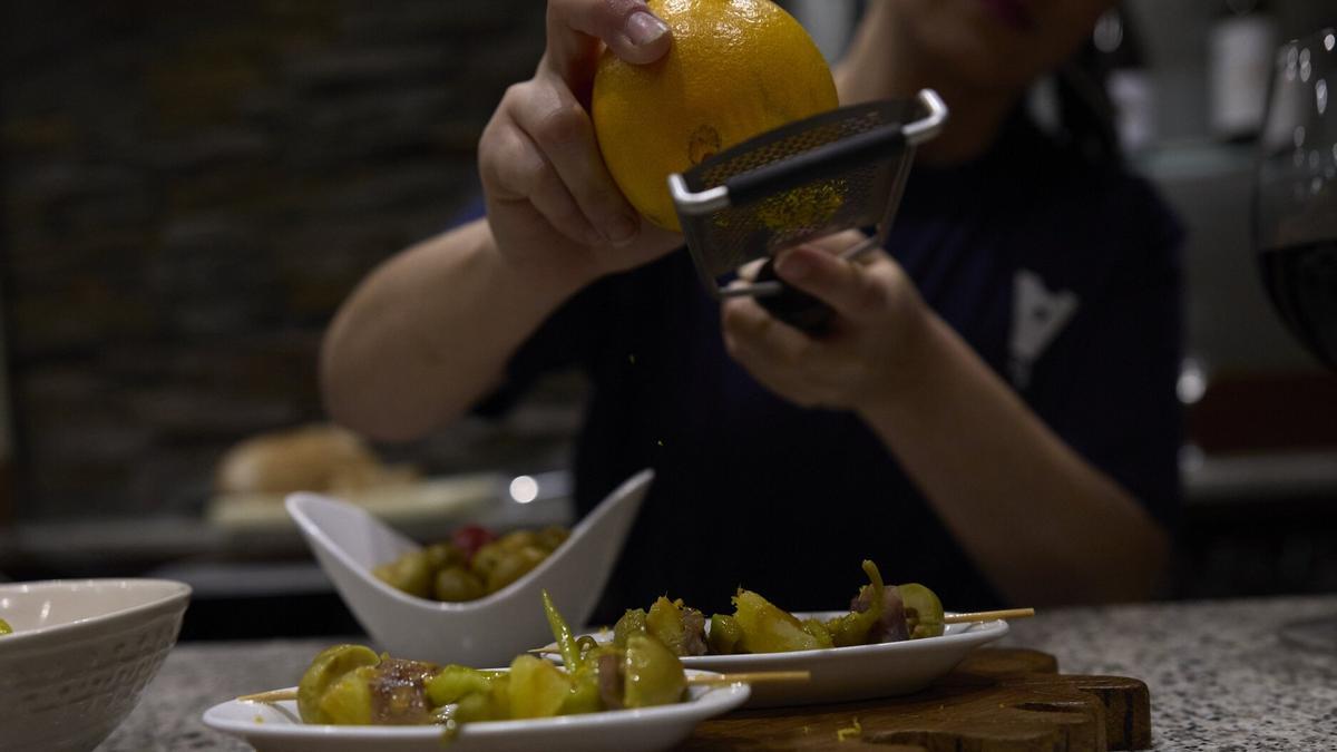 Tania Carrasco ralla la piel de la naranja para aderezar unas gildas.
