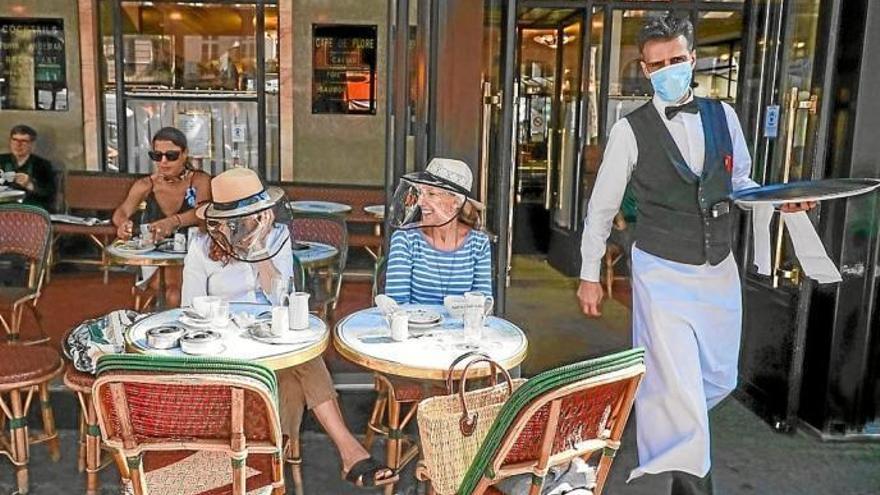 Clientes en la terraza de una cafetería en Francia.