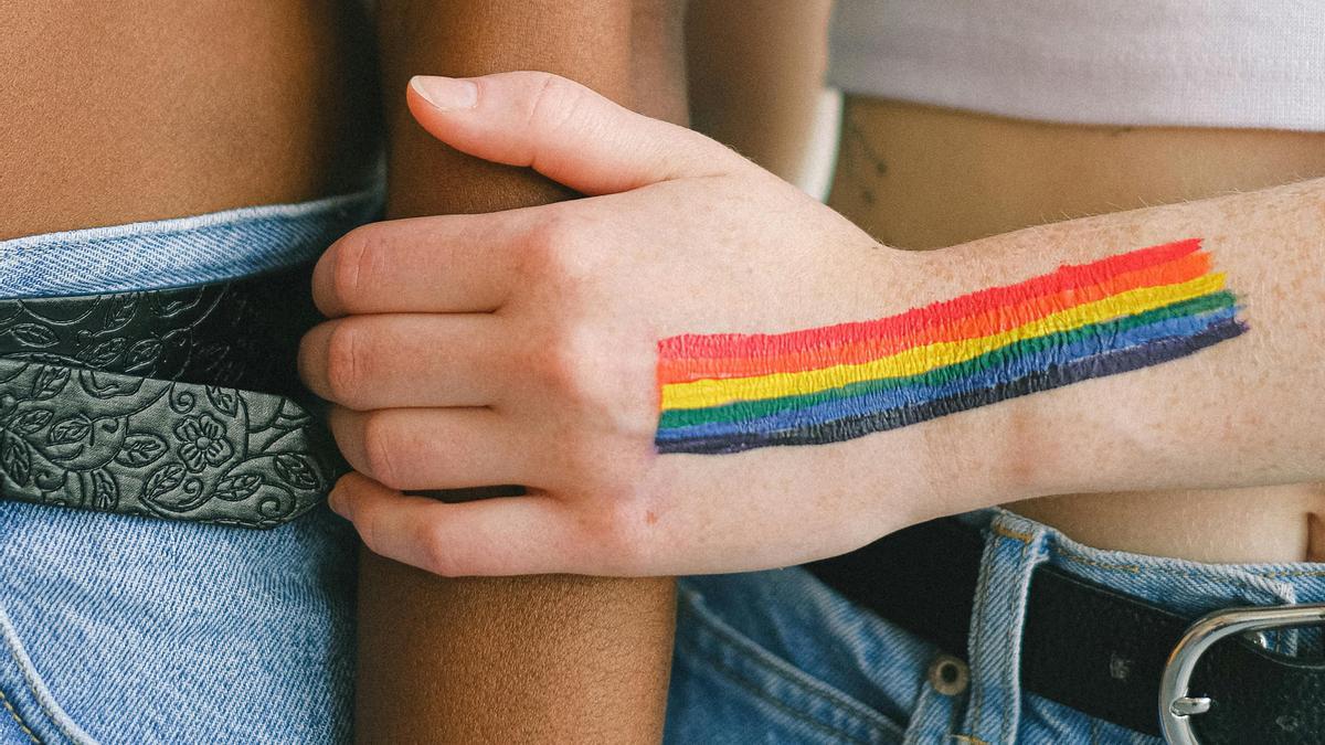 Un brazo con la bandera del orgullo LGBTI pintada.