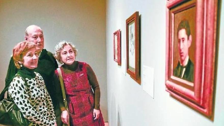 Karmele, Luis Mari y Maitena observan los retratos de su bisabuelo, Alselmo Guinea, que expone el Bellas Artes.