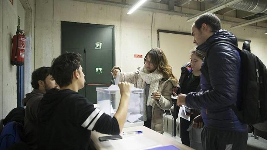 Una joven deposita su voto en un aula de la UPNA.