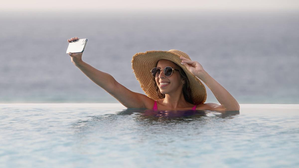 Mujer sacándose una foto en la piscina.