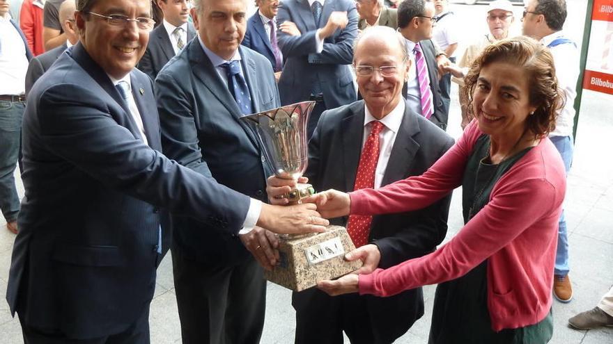 José Luis Bilbao, Ibon Areso y Cristina Uriarte sujetan la copa.