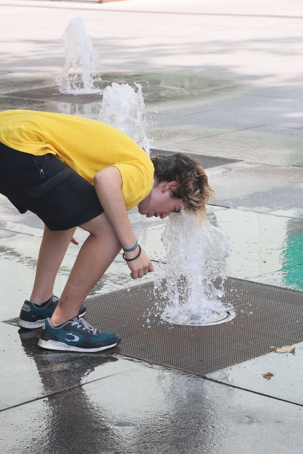 Un chaval se refresca en una fuente de Vitoria.