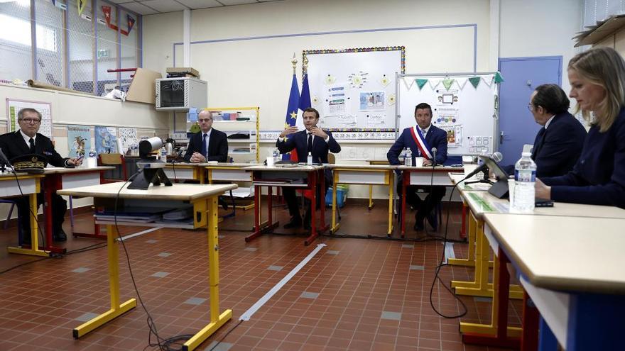 Macron, entre Blanquer y Olive, participando en una vídeoconferencia con alcaldes y directores de colegios.