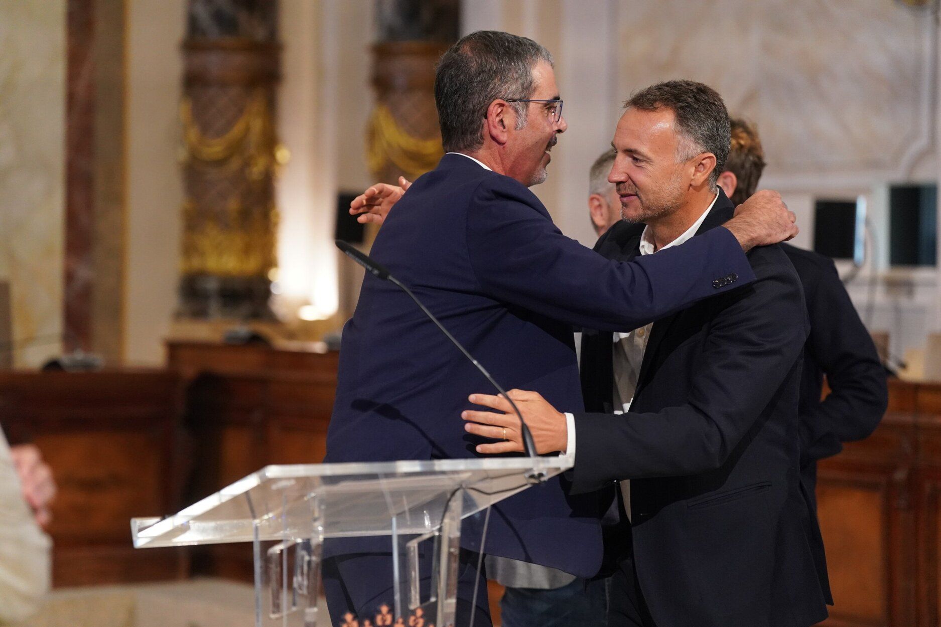 El edil de Hacienda, Kerman Orbegozo, abraza al alcalde de Donostia, Eneko Goia, tras la comparecencia en la que ha anunciado su adiós
