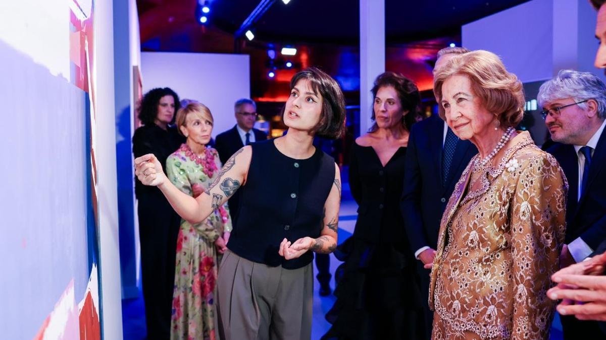 Amaya Suberviola explica a la reina emérita detalles de su pintura.