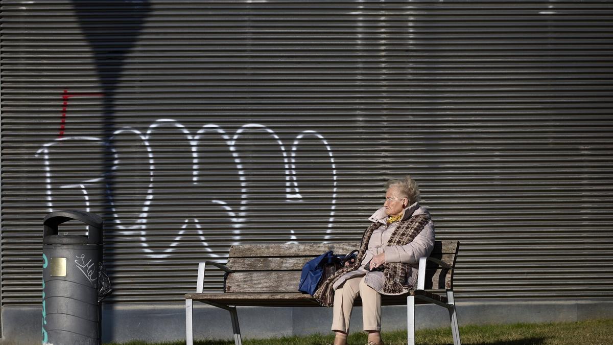 Una mujer mayor sentada sola en un banco, un perfil muy habitual entre las personas que viven solas.