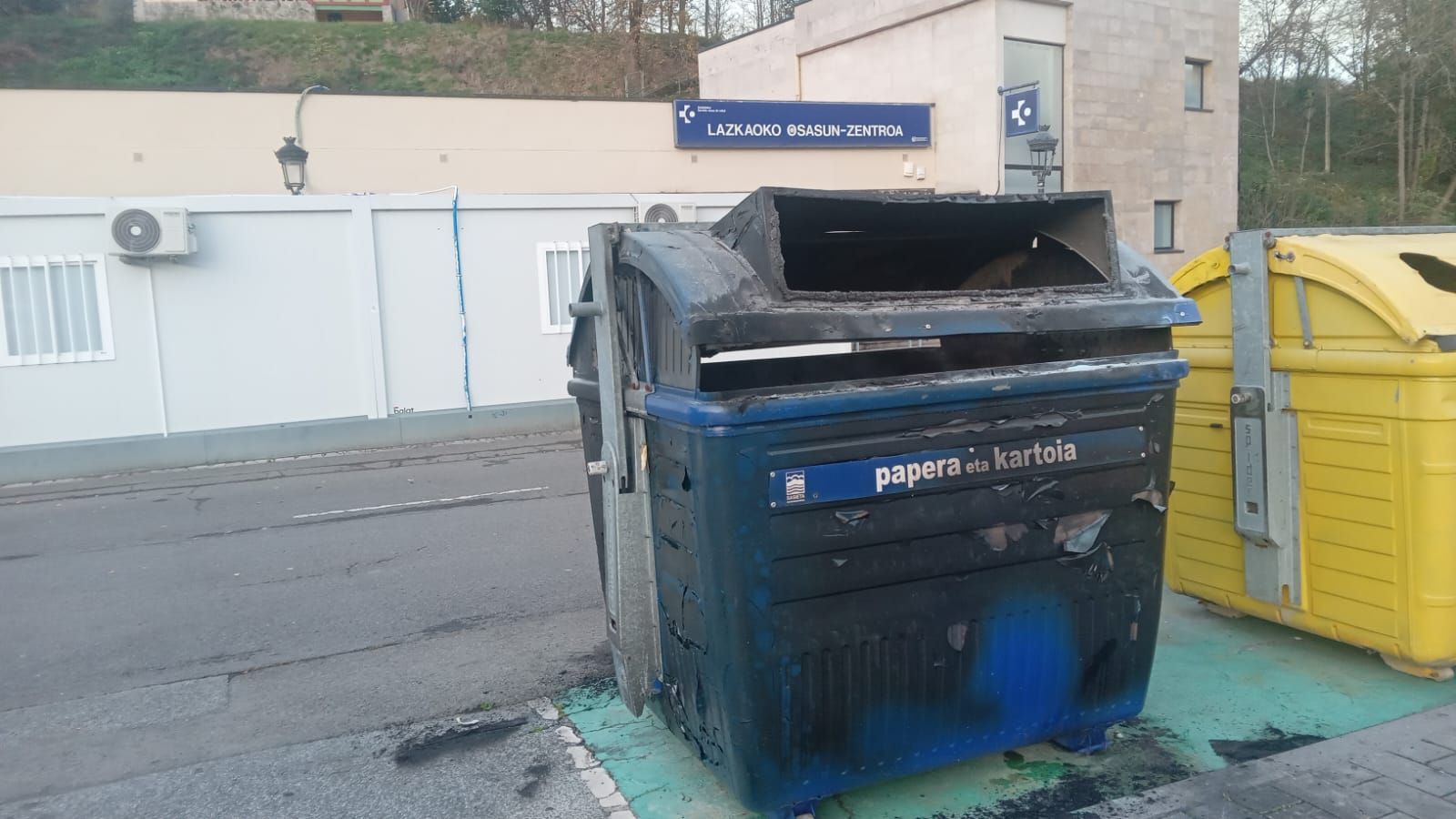 Actos vandálicos en Lazkao: contenedores quemados y pintada en el frontón
