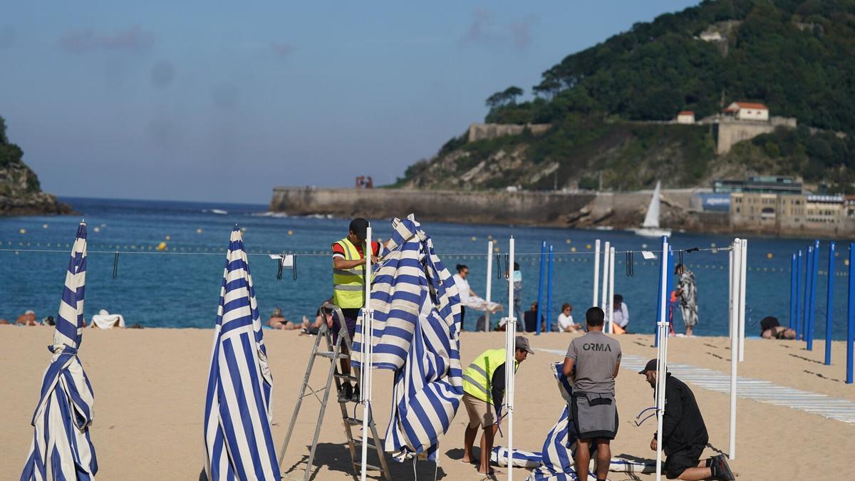 Operarios municipales retiras los toldos de las playas donostiarras