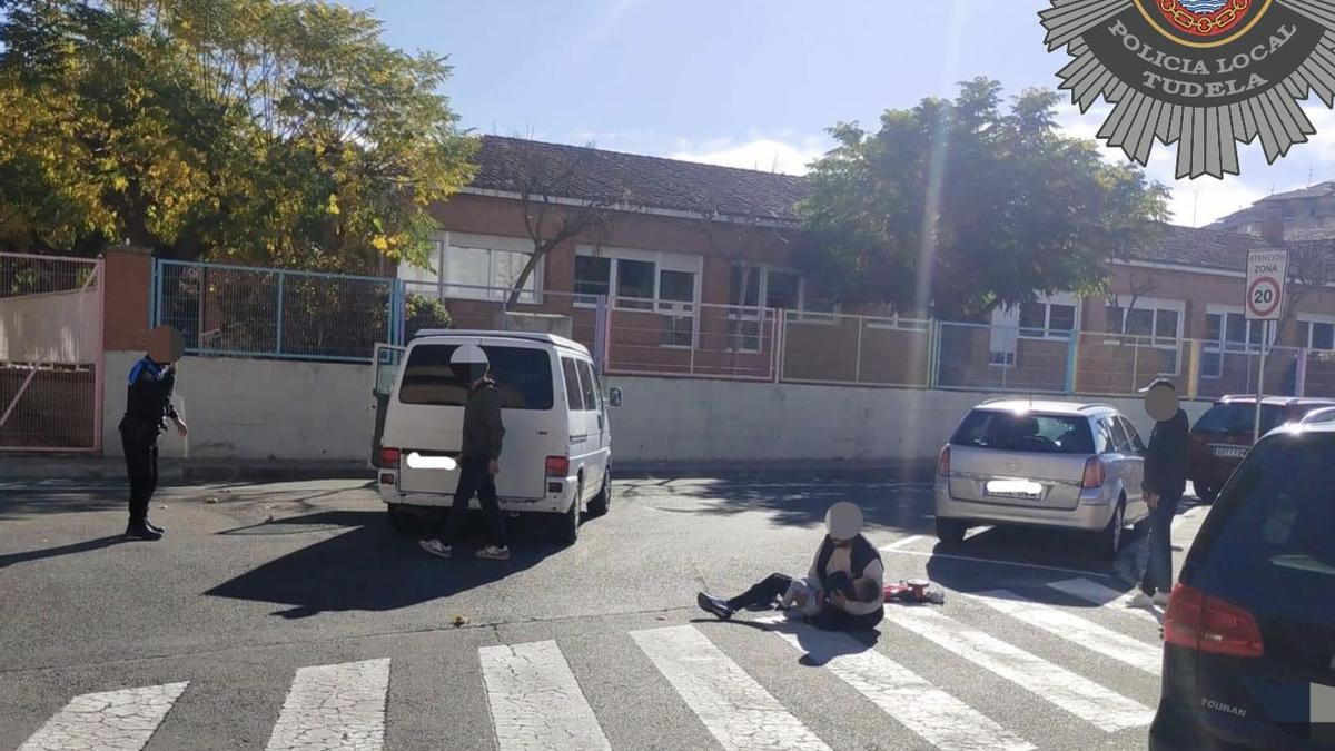 El niño de año y medio, abrazado por su padre en el suelo.